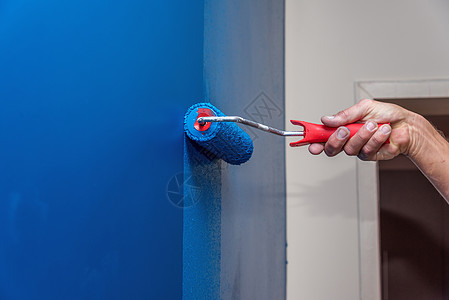 将墙涂成蓝色的工人男人画笔刷子工作装潢师装饰工具色调房子墙纸图片