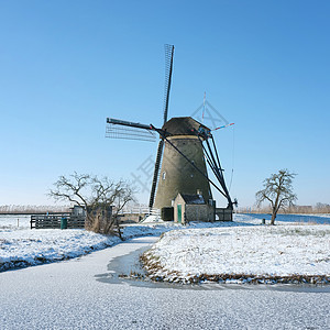 蓝天空下霍兰的寒风雪中风车图片