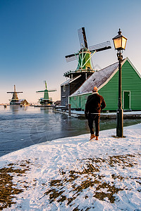 荷兰村的风车雪 冬季历史上的木制风车建筑旅游房子桑色农村博物馆天空建筑学村庄旅行图片