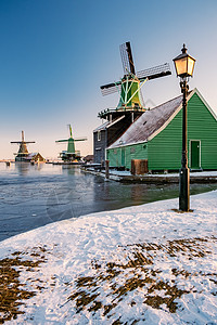 荷兰村的风车雪 冬季历史上的木制风车桑色历史性天空房子农村博物馆蓝色文化传统建筑图片