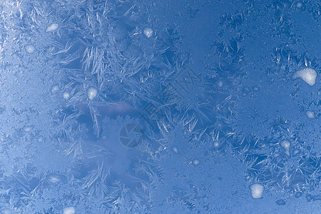 雪花透明在一个非常寒冷的冬日 窗户上美丽的冰花霜花宏观水晶磨砂薄片天空蓝色森林季节石头背景
