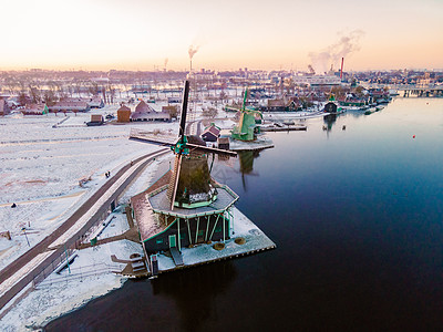 荷兰村的风车雪 冬季历史上的木制风车天空反射村庄房子桑色旅游旅行建筑学文化蓝色图片