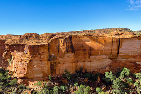 澳州艾尔斯岩澳大利亚北区Watarka国家公园峡谷墙的视图 澳大利亚北方领土侵蚀蓝色红色木头爬坡橙子地质学土著中心巨石背景