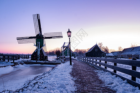 在冬季风车村 雪覆盖了荷兰的木制历史风车荷兰降雪农村地方天空灯笼桑色建筑学建筑纪念碑村庄图片