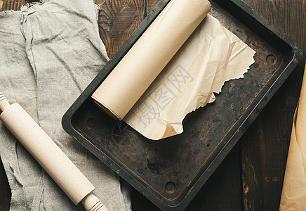 用棕色纸纸和纸卷覆盖的空长方形金属板木板厨具家庭器具羊皮纸用具木头食物工具厨房图片