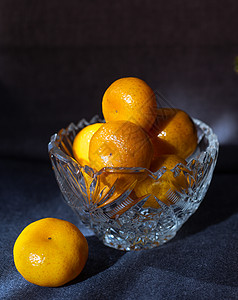 深底的晶体花瓶中的黄橘子背景图片
