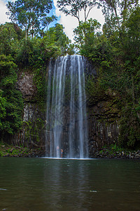 站在面粉山瀑布下的人 在澳洲昆士兰州淋浴图片