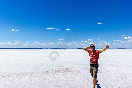 年轻人在盐湖上玩得开心 在澳洲西部的盐湖上 秘密微笑男人力量享受反射世界通电愈合成人假期太阳图片