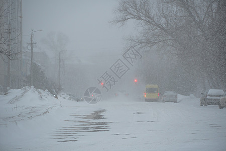 在暴风雨 暴风雪或冬季降雪中 在城市的恶劣天气下 一条空荡荡的积雪覆盖的道路 北方的极端冬季天气状况图片