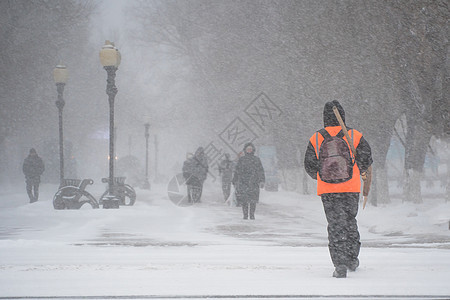 市政服务的一名工作人员带着雪铲在暴风雨 暴风雪或冬季降雪中在城市的恶劣天气中沿着道路行走 北方的极端冬季天气条件气候预测气旋磨砂图片