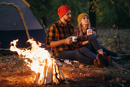 一对年轻夫妇 一个男人和一个女孩 戴着漂亮的编织帽子 在露营时停下来了天空橙子旅行衬衫金发女郎胡须女孩取暖数字温暖图片