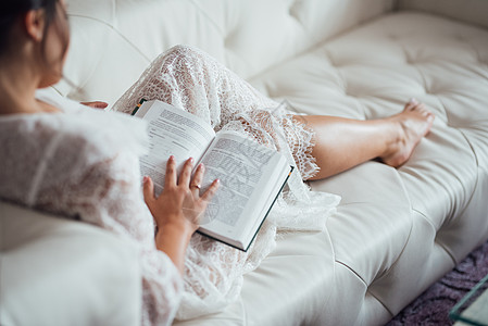 沙发看书女孩黑发女孩读俄文的一本书新娘沙发美甲阅读压痛床单指甲图书馆白色头发背景