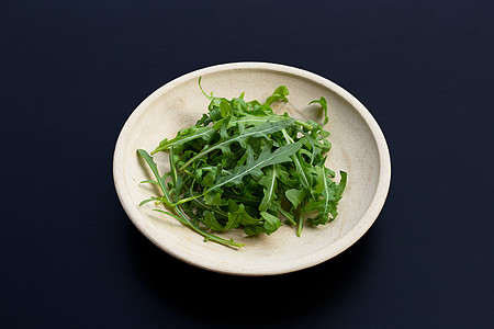 在黑暗的背景的新鲜的绿色火箭沙拉美食叶子树叶植物菊苣包装饮食食物草本植物蔬菜图片