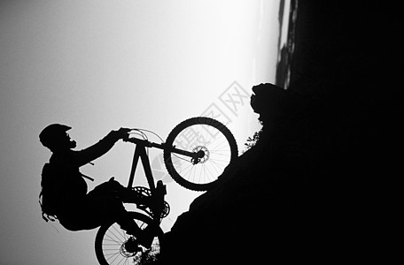 黑白照片 山上骑自行车者滑下斜坡图片