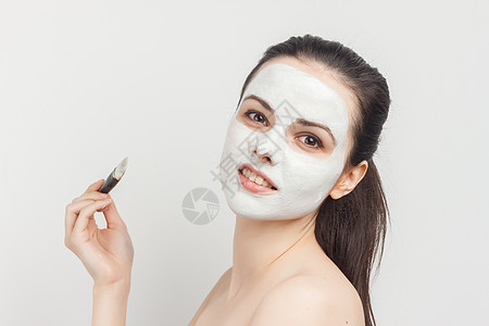 漂亮漂亮的女人在脸部皮肤护理上施刷霜 恢复活力身体化妆品奢华海绵工作室浅色擦洗沙龙面具女性图片