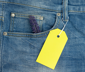 蓝色牛仔裤背景上的空白长方形纸板黄色标签图片