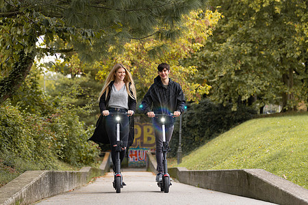 时髦时髦的青少年在城市公园里骑公共租赁电动滑板车 斯洛文尼亚卢布尔雅那新型环保现代公共城市交通夫妻朋友们公园女孩游客力量活动微笑图片