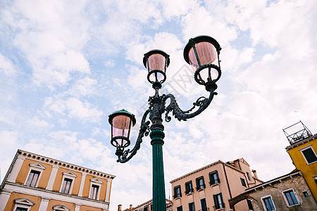古老的三重金属街灯 粉红色广场对着意大利威尼斯的天空和建筑物 高贵的街道照明 优雅的柱子设计图片