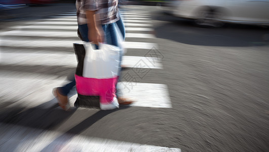 提着购物袋过马路的女人行人路口女性白色运动路面黑色成人城市人行道图片