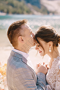新婚夫妇在意大利布拉埃斯湖的背景下 以秋天的花柱拱门为仪式现场亲吻 在欧洲的目的地婚礼 在 Braies 湖上恋人游客套装岩石蕾图片