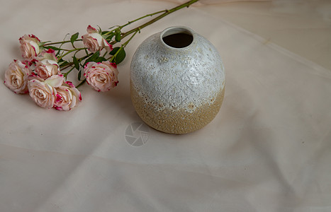 白色和黄色手工陶瓷花瓶 红色纹理桌布上有一束花装饰作品制品家具风格手工业陶器热情材料艺术图片