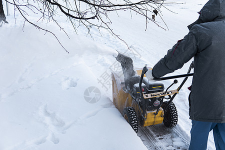 暴风雪过后 男子用造雪机清理车道 在街道上工作的除雪设备 从雪中清理街道 正在下雪车辆技术男性工具投掷者机械蓝色引擎机器雪堆图片