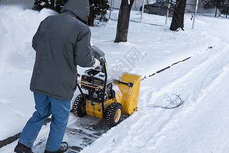 暴风雪过后 男子用造雪机清理车道 在街道上工作的除雪设备 从雪中清理街道 正在下雪鼓风机车辆发动机天气风暴季节降雪工人男性行动图片