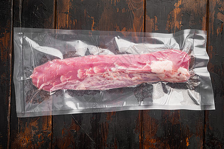 旧黑木制餐桌底的肉制品猪排鲜嫩蛋面板 真空包装图片