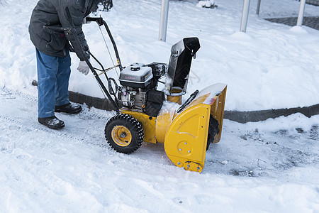 暴风雪过后 男子用造雪机清理车道 在街道上工作的除雪设备 从雪中清理街道 正在下雪机器男人鼓风机降雪行动人行道拖拉机车辆机械技术图片