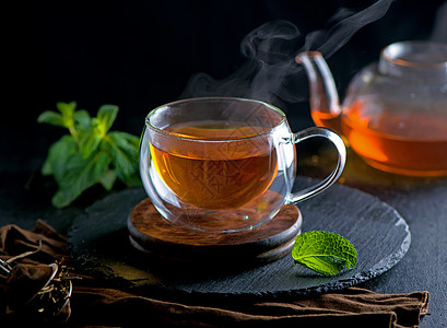 茶叶概念 茶壶和茶茶 以木为背景 茶仪式 在透明杯子里的绿茶生活文化叶子小样菜单食物植物高架茶点排毒图片