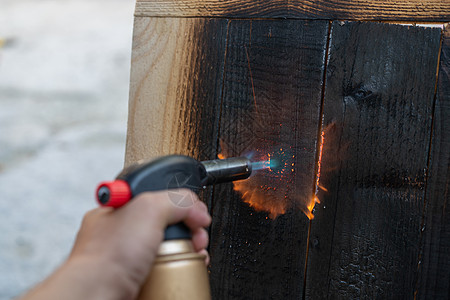 使用古老的传统日本技术的专业木匠 用煤气燃烧的燃烧木板火焰烧伤工人材料蓝绿色工艺建筑师木制品木材工具图片