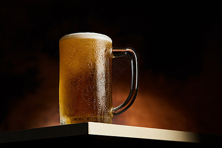 在木制桌上的杯子啤酒啤酒厂木头酒精玻璃泡沫茶点金子黄色庆典酒吧图片