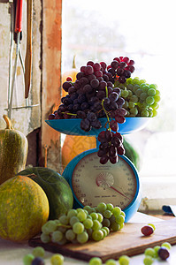 秋天的静物画里有南瓜 西瓜 西瓜 葡萄 还有秤上的葡萄 放在白木桌上的金属碗里 秋天收获的概念 感恩节快乐 选择性的焦点 设计模图片