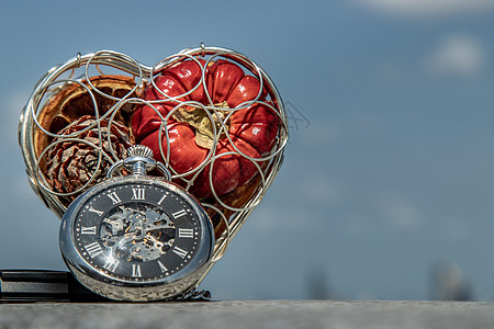 心形礼盒中的水果和以天空为背景的怀表作为爱情的象征时间手表礼物金属浆果艺术口袋恋情生活图片