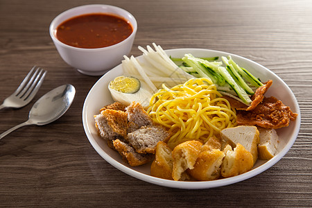 Mee Rojak是马来西亚印度面条加花生酱蔬菜食物肉汁豆腐花生油炸坚果油条美食盘子图片