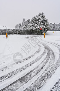 冬季轮胎在雪路转弯处留下痕迹 前面有停车牌温度锥体气候白色警告旅行橙子季节情况图片