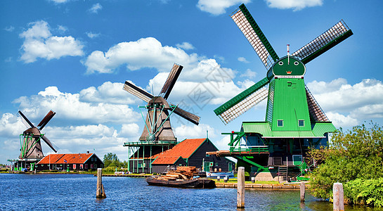 荷兰风车停在靠近荷兰阿姆斯特丹的绿色农村 有蓝天和河流水村庄国家游客房子旅游地标旅行历史蓝色场地图片