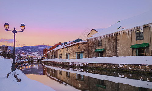 小樽店日本北海道(北海道)的Otaru Canel在冬季与日落背景