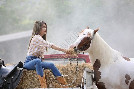 一名身着女牛仔风格的妇女坐在西部农场环境的马场里女士草地骑术友谊场地骑士农村动物牧场荒野图片