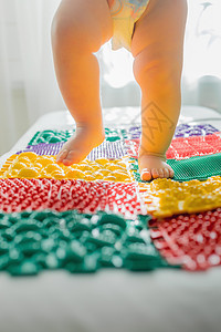 这孩子赤脚走在多色按摩地毯上程序婴儿保健步态脚跟锻炼身体素质足部童年脚趾图片