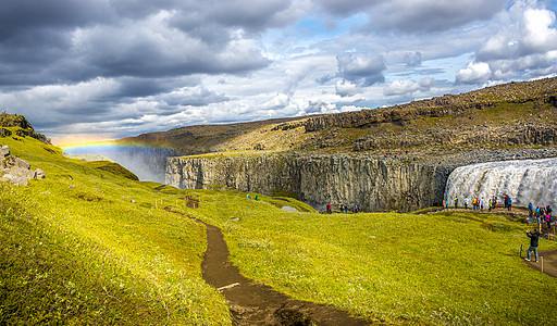 欧洲最大和最强大的瀑布的全景 称为冰岛的 Dettifoss 靠近 Myvatn 湖 在戏剧性的天空中有彩虹 游客 夏天图片