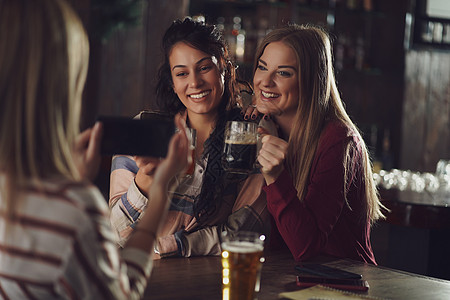 酒吧里的朋友女朋友金发女郎啤酒啤酒杯快乐拍照头发乐趣女士女性图片