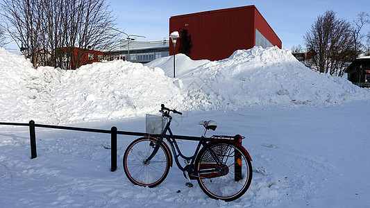 一辆自行车停在瑞典基律纳市中心的雪地街道上天空运动公园男人自由运输冒险街道假期季节图片