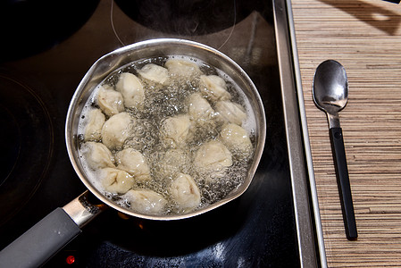 俄国人用沸水中龙卷风煮开的锅里 将猪排在沸水中勺子饮食食谱水饺饺子产品厨具烹饪面团营养图片