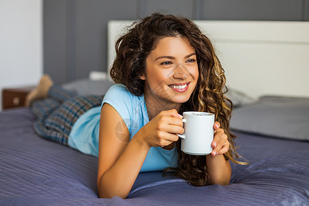 女人在床上喝咖啡棕色头发咖啡喜悦睡衣睡眠沉思寝具枕头杯子图片