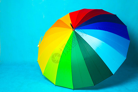 蓝色背景上的彩色雨伞 亮伞 复制空间庆典天气安全旅行阳伞配饰太阳橙子彩虹季节图片