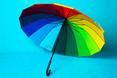 蓝色背景上的彩色雨伞 亮伞 复制空间安全天气季节太阳阴影橙子配饰庆典彩虹阳伞图片
