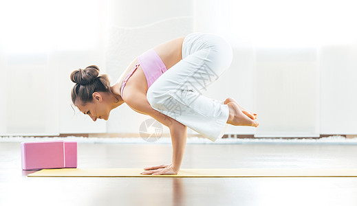 在她的健身房表演乌乌鸦姿势时 适合体操的瑜伽教练高清图片