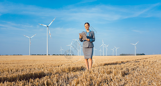 妇女将资金投入符合道德的风力涡轮机投资女士粮食场地风能商业数据变化人士电脑药片图片
