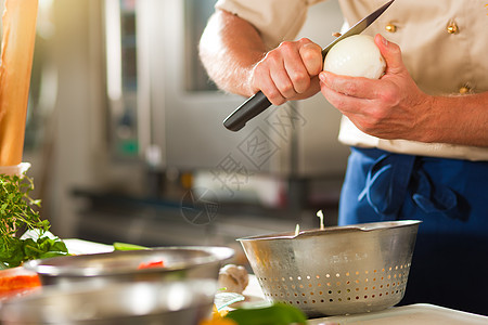 在餐厅或旅馆厨房做洋葱主厨酒店男性食物成人商业男人蔬菜烹饪背景图片